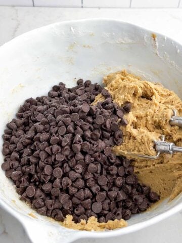 cookie dough and chocolate chips in a white mixing bowl.