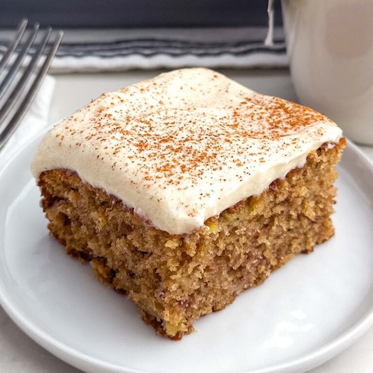 a banana bar with cream cheese frosting on a white plate.