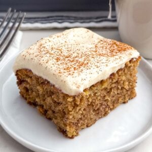 a banana bar with cream cheese frosting on a white plate.
