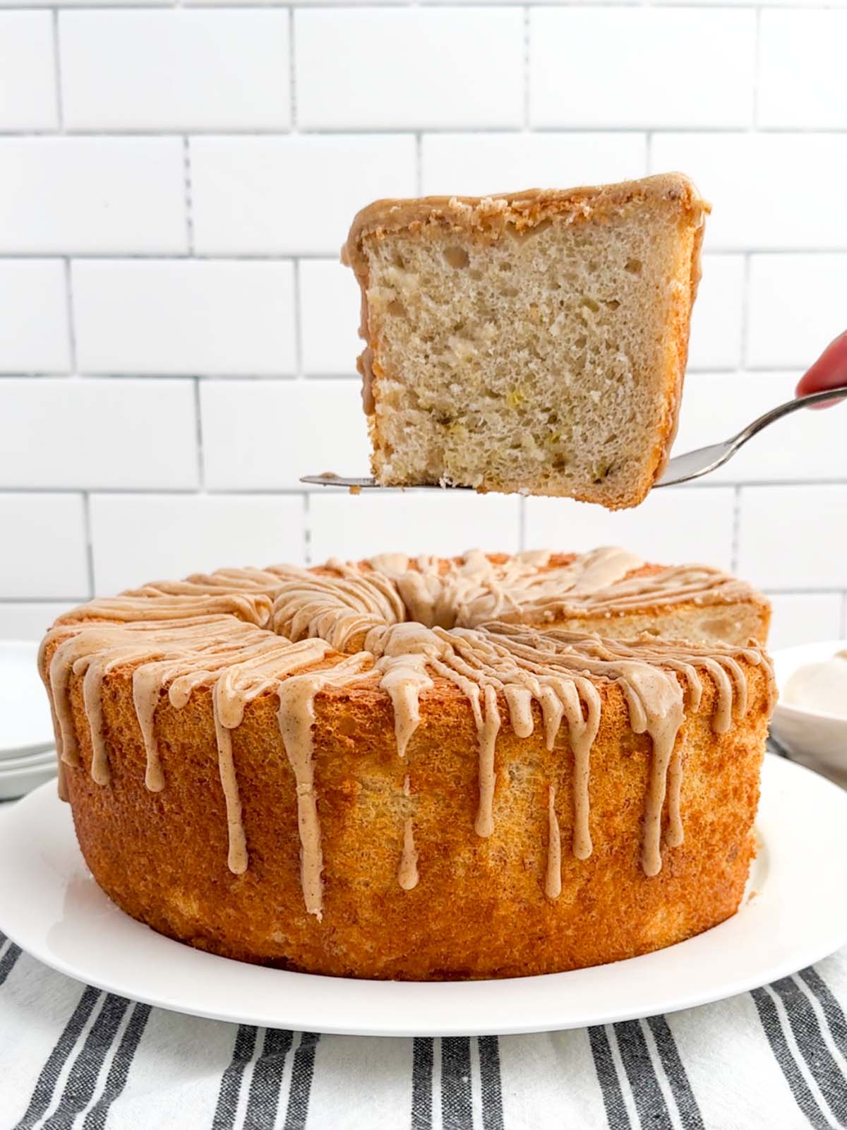 cake server lifting a piece of banana angel food cake over the rest of the cake.