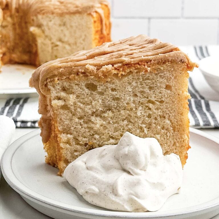 a piece of cake mix banana angel food cake on a plate with cinnamon whipped cream.