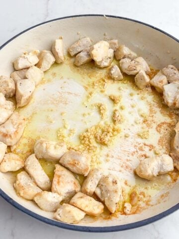 cooked chicken and garlic in a Dutch oven.