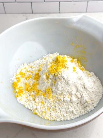 lemon cake mix and lemon zest in a white bowl.