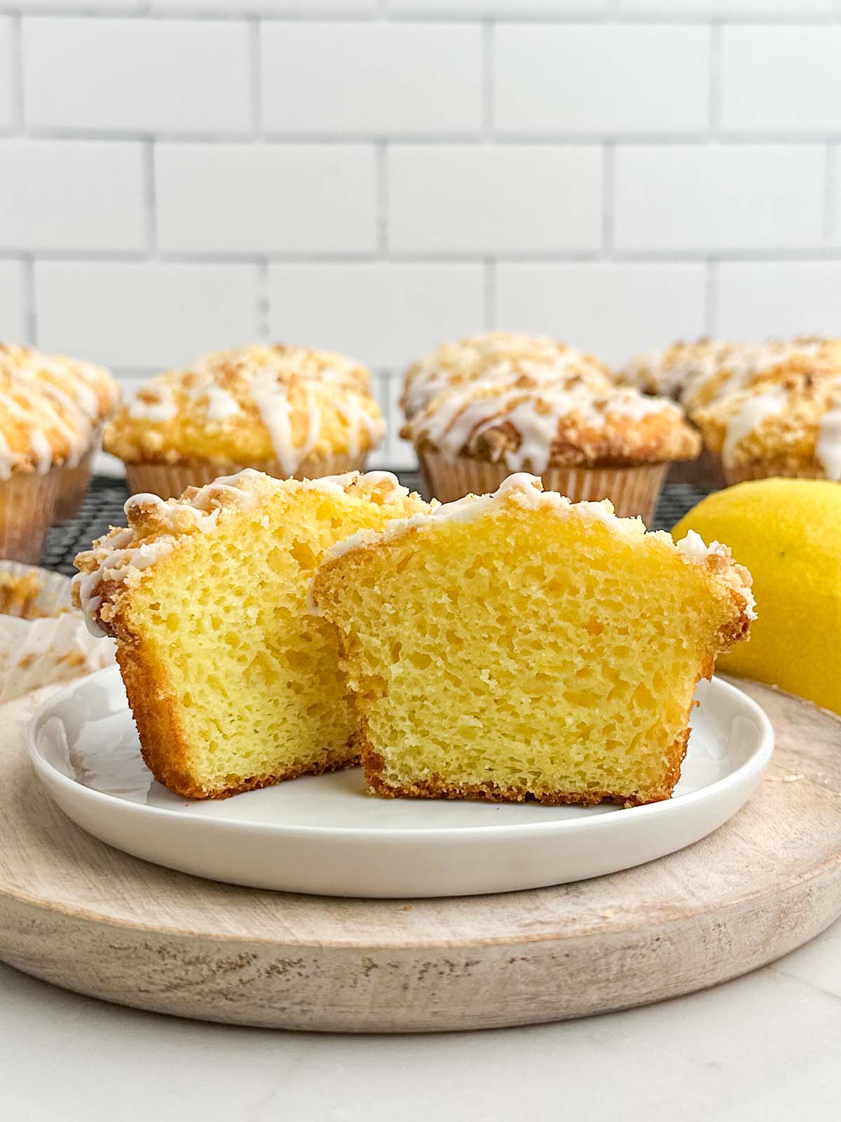a lemon cake mix muffin cut in half on a white plate.