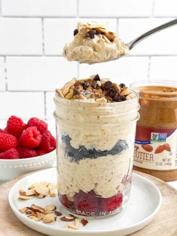 mason jar of almond butter overnight oats with a spoonful lifted above it.
