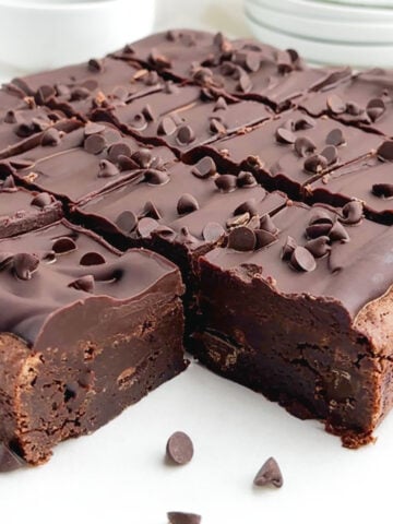 chocolate ganache brownies cut into squares on white parchment paper.