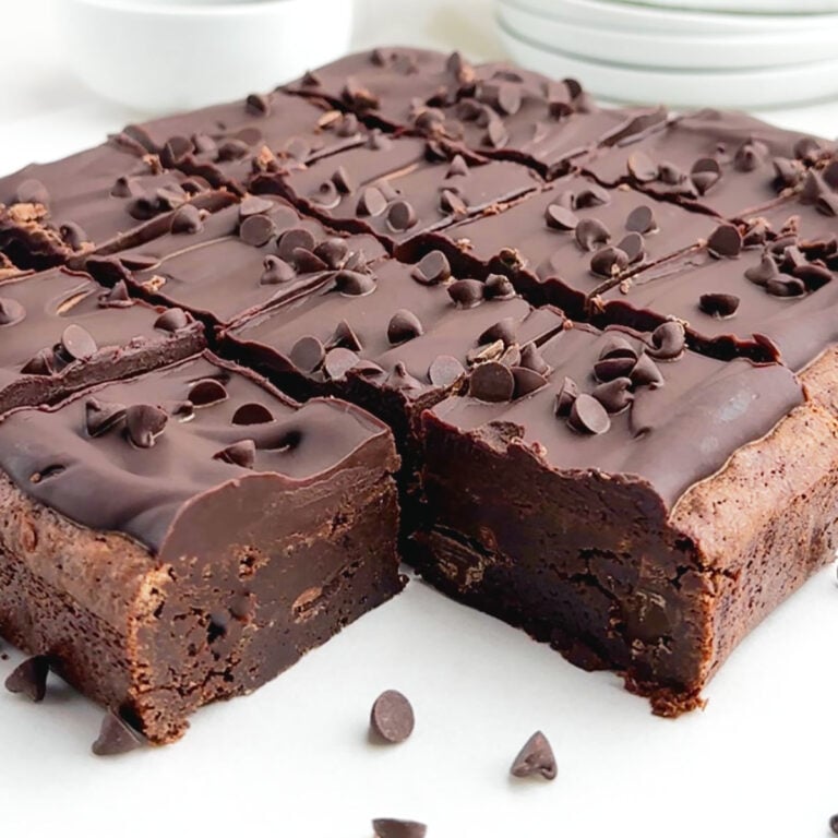 chocolate ganache brownies cut into squares on white parchment paper.