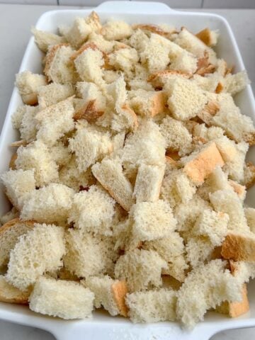 bread cubes in a white 9 x 13 baking dish.