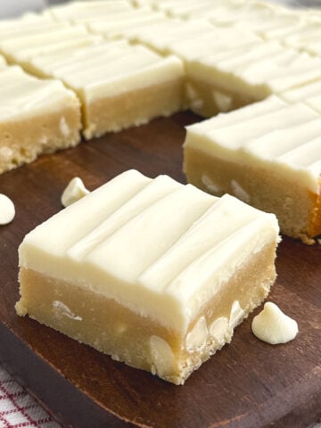 white chocolate brownies on a wooden cutting board.