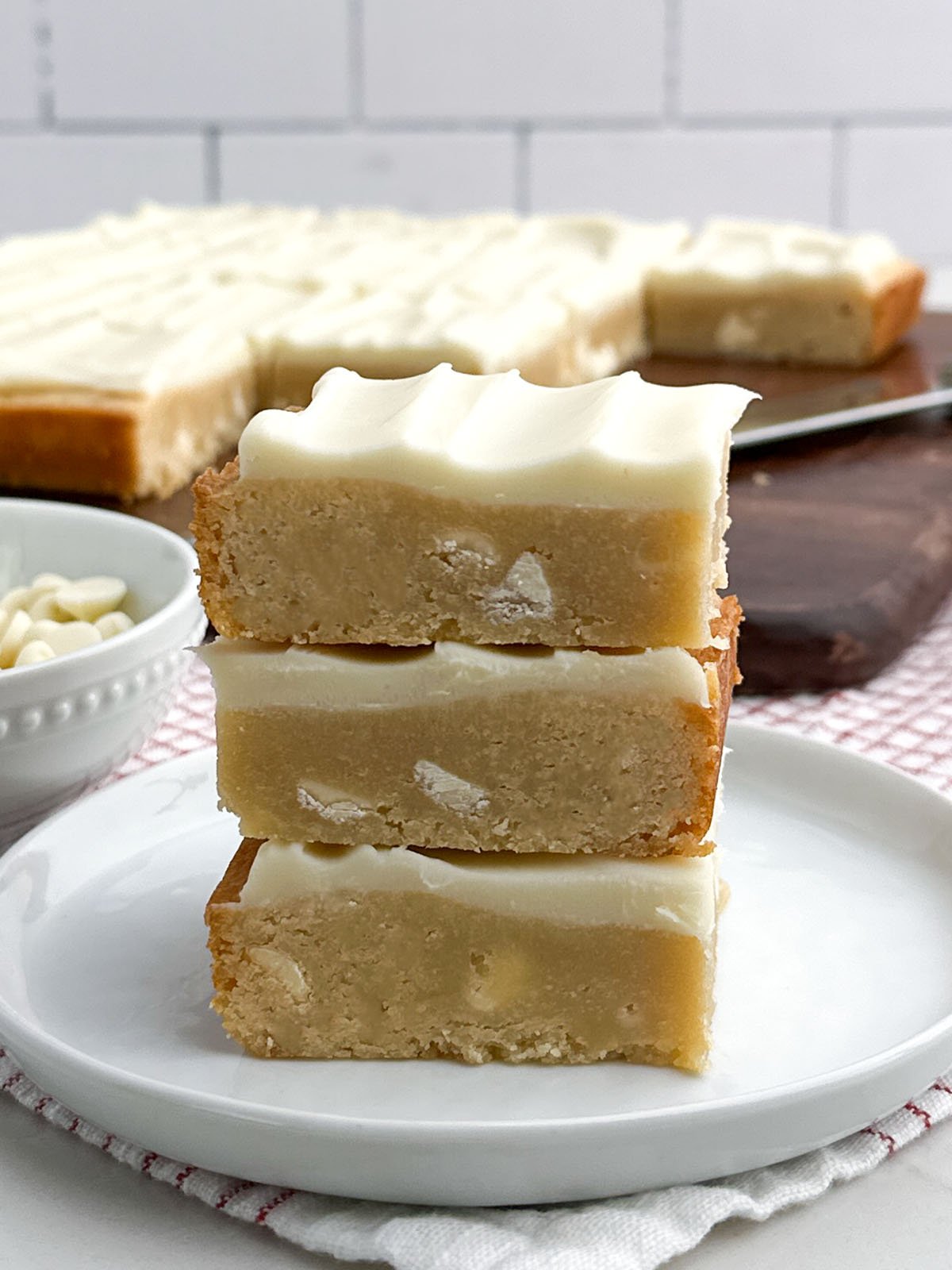 stack of white chocolate brownies on a white plate.
