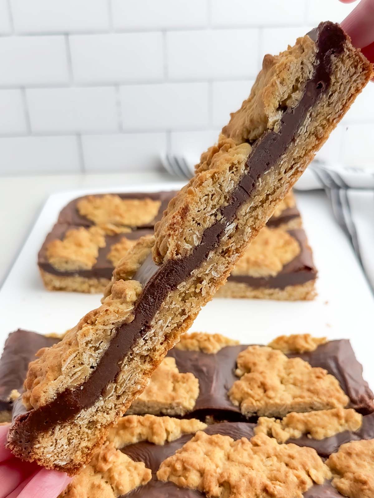 hands holding up a row of chocolate revel bars.