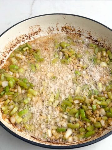 onions and celery sauteing in a Dutch oven.