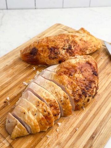 turkey breasts on a wooden cutting board.