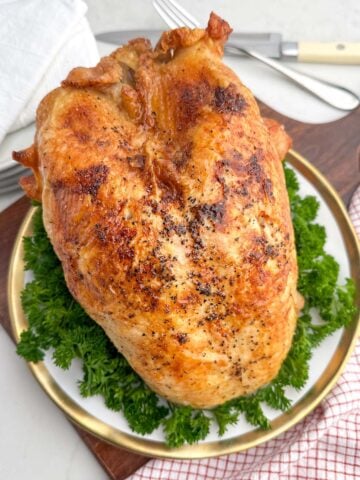 roast bone-in turkey breast on a white plate.