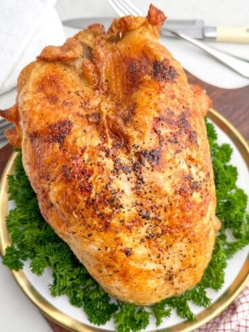 roast bone-in turkey breast on a white plate.