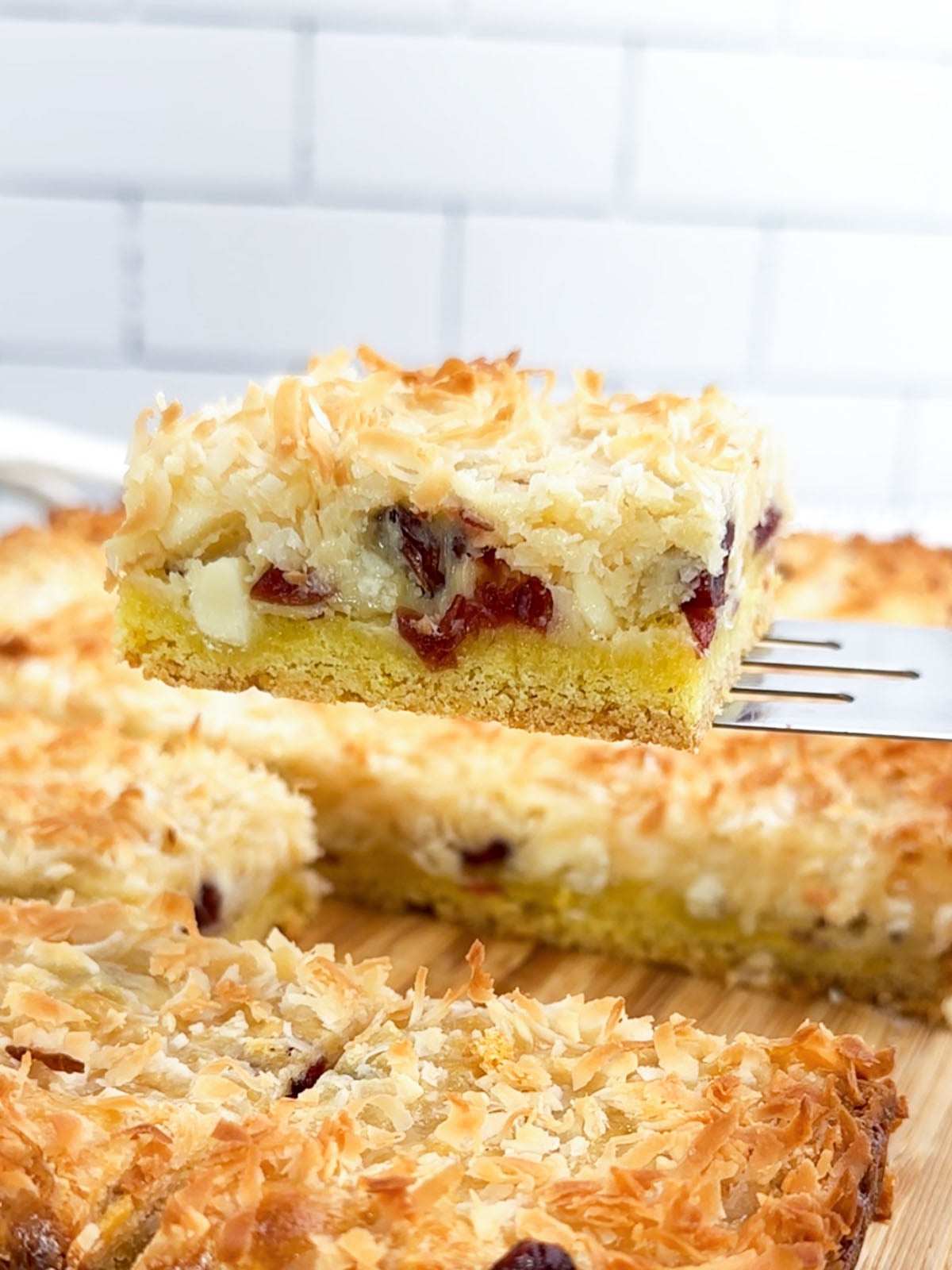 a spatula lifting a lemon coconut cranberry cake mix bar.