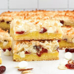 a stack of lemon cake mix white chocolate cookie bars on a white countertop.