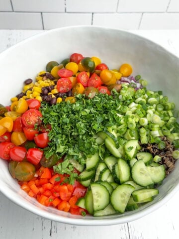 corn and wild rice salad ingredients in a white bowl.